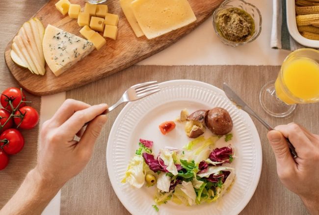 A vibrant lunch setting with salad, cheese, and orange juice, perfect for a healthy meal.